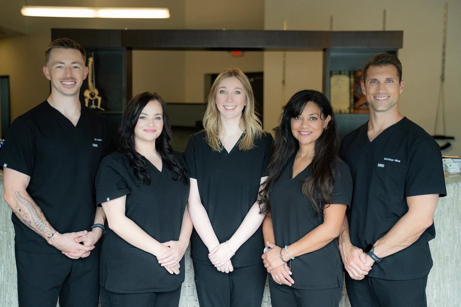The Cool Springs Chiropractic doctors and team in matching black scrubs